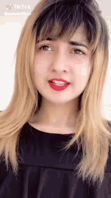 a close up of a woman 's face with tiktok written on the bottom right