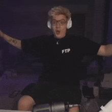 a man wearing headphones and a black shirt that says ptt on it