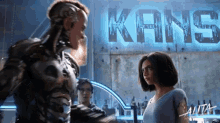 a man and a woman standing in front of a kans sign