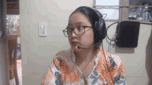a woman wearing glasses and headphones with a microphone on her head