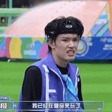 a man wearing a headband and a purple vest stands in front of a sign that says ' chinese ' on it
