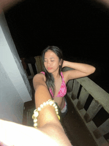 a woman in a pink bikini taking a selfie with her eyes closed