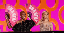 a woman holding a fan with the word shantay on it