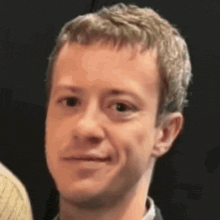 a close up of a man 's face with a black background .