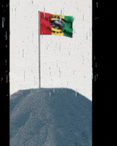 a flag is waving in the rain on top of a hill