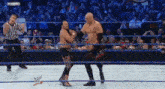 two wrestlers are fighting in a wrestling ring with a referee in the background