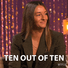 a woman in a suit is smiling and says ten out of ten netflix