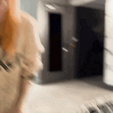 a blurry picture of a woman standing in a hallway .