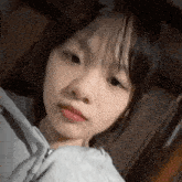 a close up of a young girl wearing a gray hoodie looking at the camera .