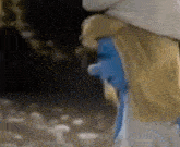 a close up of a smurf wearing a white hat and a blue face .
