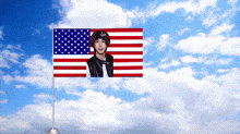 an american flag with a picture of a young man floating in the sky