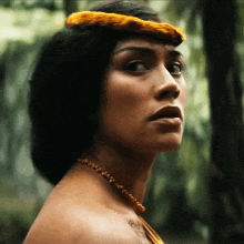 a close up of a woman 's face with a necklace on her neck