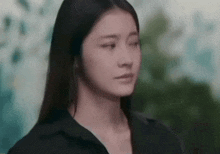 a close up of a woman 's face with her eyes closed and a serious look on her face .