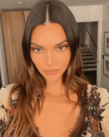 a close up of a woman 's face with a staircase in the background .