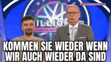 a man in a suit and tie is standing next to another man in front of a wheel that says million .