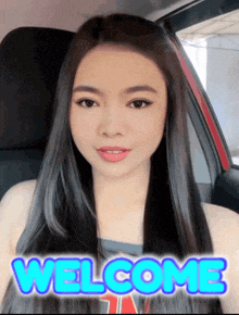 a woman is sitting in a car with the words welcome written on her face