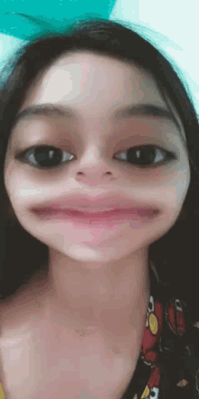 a close up of a girl making a funny face with her mouth open .
