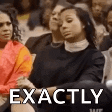 a woman is sitting in a crowd with her eyes closed and the word exactly written on her face .