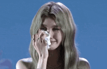 a woman with green hair is crying and holding a napkin
