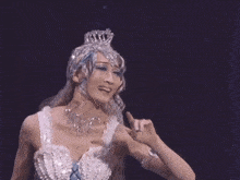 a woman in a blue and white dress with pearls on it