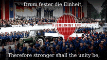 a group of people marching in front of a sign that says " vereinigt euch "