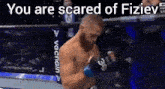 a man in a boxing ring with the words `` you are scared of fiziev '' written on the bottom