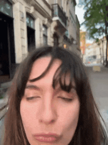 a woman with her eyes closed is making a funny face