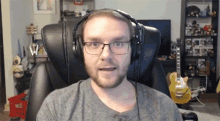 a man wearing headphones and glasses is sitting in a chair
