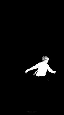 a black and white photo of a man jumping in the air with his arms outstretched .