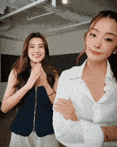two women are standing next to each other with their arms crossed and smiling