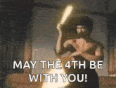 a man without a shirt is holding a light saber and saying may the 4th be with you .
