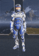a man in a blue and white armor stands in front of mountains