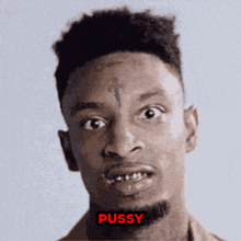 a man with a cross tattoo on his forehead has the word pussy written on his face
