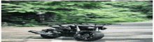 a motorcycle is driving down a road next to trees .