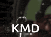 a man singing into a microphone with kmd written in white