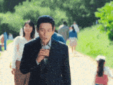 a man in a suit drinking a drink through a straw