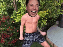 a shirtless man with a picture of elon musk on his head is dancing in a garden .