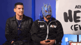 a man wearing a mask and a jacket that says aew