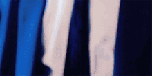 a blurred image of a person 's arm with a blue and white striped shirt