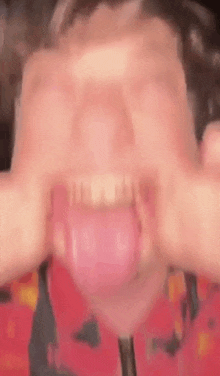 a close up of a person making a face with their mouth open .