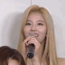 a close up of a woman holding a microphone .