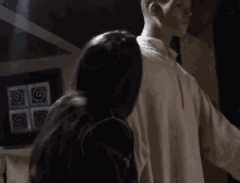 a woman is standing next to a mannequin in a white shirt