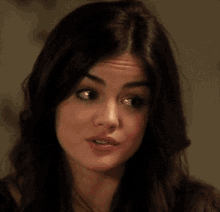 a close up of a woman 's face with dark hair and pink lips