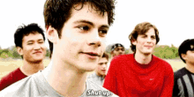 a group of young men are standing in a field and one of them is saying shut up