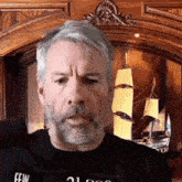a man with a beard is wearing a black shirt with the word few on it