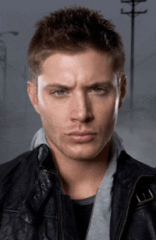 a close up of a man 's face wearing a black leather jacket