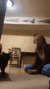 a woman playing with a cat in a living room with a banner on the ceiling that says ' cleveland '