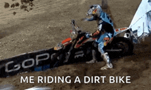 a man is riding a dirt bike on a dirt track and says me riding a dirt bike