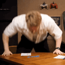 a man is bending over in front of an official art sign