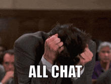 a man in a suit is covering his face with his hands and the words all chat are written below him